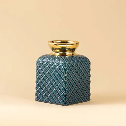 Side angle of blue ceramic vase with embossed diamond texture and metallic gold neck showing depth and glossy finish.