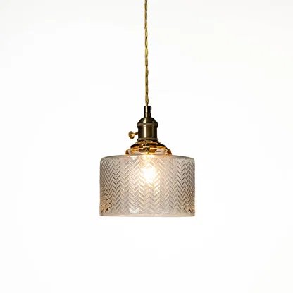 Textured clear glass and brass metal pendant light designed for elegant dining room decor spaces.