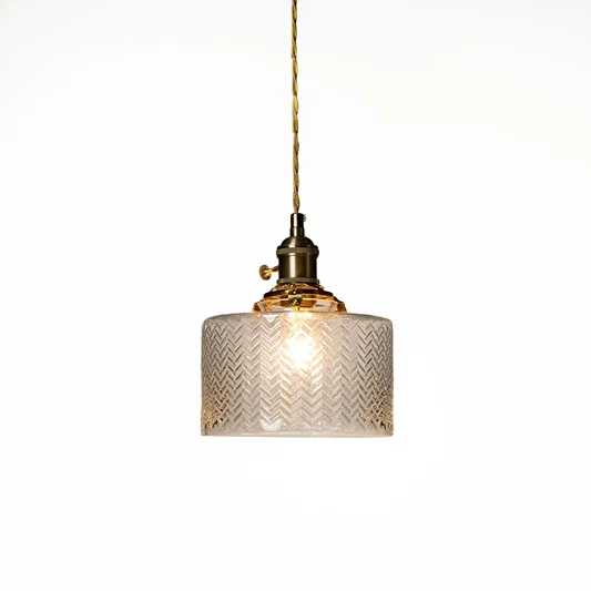 Textured clear glass and brass metal pendant light designed for elegant dining room decor spaces.