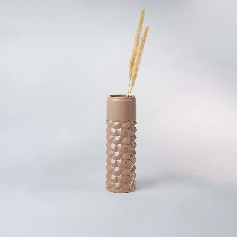 Beige geometric ceramic vase displayed in a subtle lifestyle scene highlighting its tall shape and contemporary textured surface.