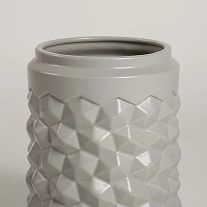 Detailed close view of the grey ceramic vase showing its raised geometric texture and smooth finish for a modern decorative appeal.