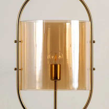 Gold metal wall light with amber glass shade closeup showcasing premium craftsmanship and elegant decorative detailing.