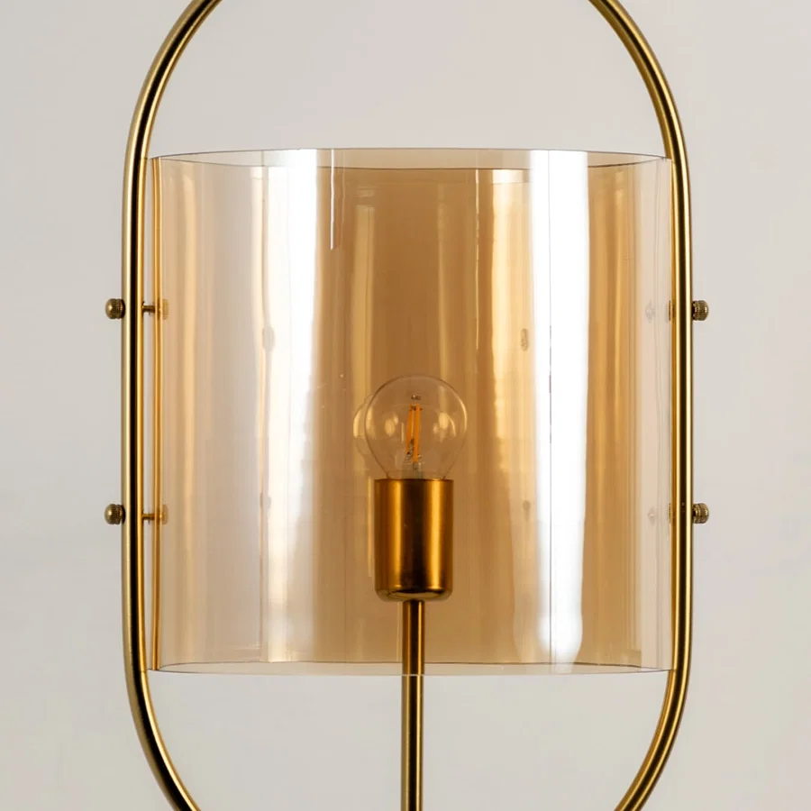 Gold metal wall light with amber glass shade closeup showcasing premium craftsmanship and elegant decorative detailing.