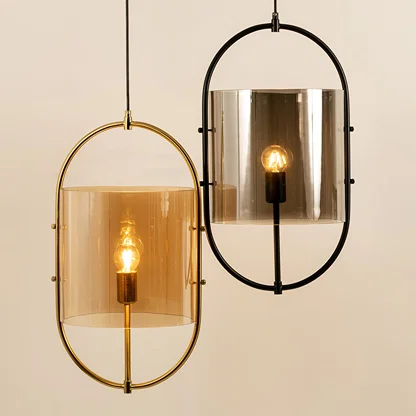 Gold and black metal wall lights with smoked glass shades illuminated to showcase luxury modern wall lighting.