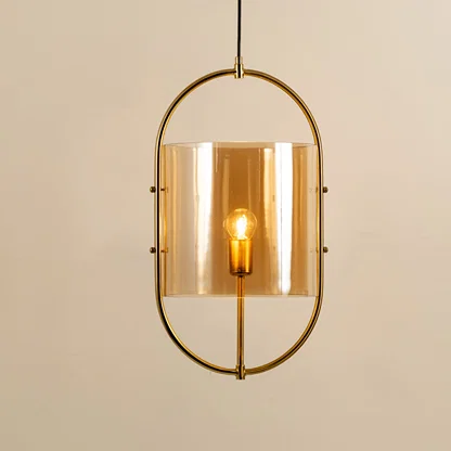 Elegant gold metal pendant light with amber glass shade for stylish dining room and kitchen decor styling.