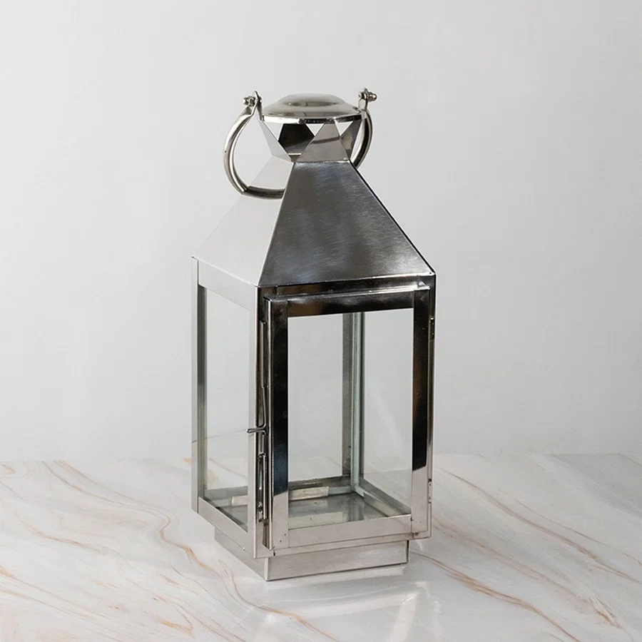 Stainless steel lantern turned off displayed plain on white background highlighting polished finish.