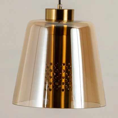Amber glass and gold metal pendant light illuminated to showcase luxury ceiling lighting with warm decorative appeal.