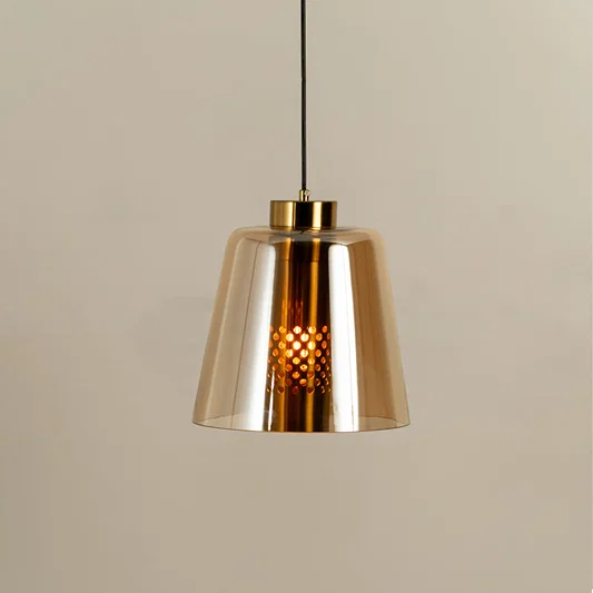 Gold metal pendant light with amber glass shade illuminated to showcase modern decorative ceiling lighting appeal.