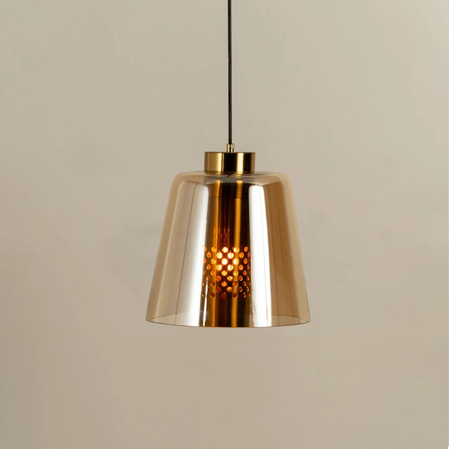 Gold metal pendant light with amber glass shade illuminated to showcase modern decorative ceiling lighting appeal.