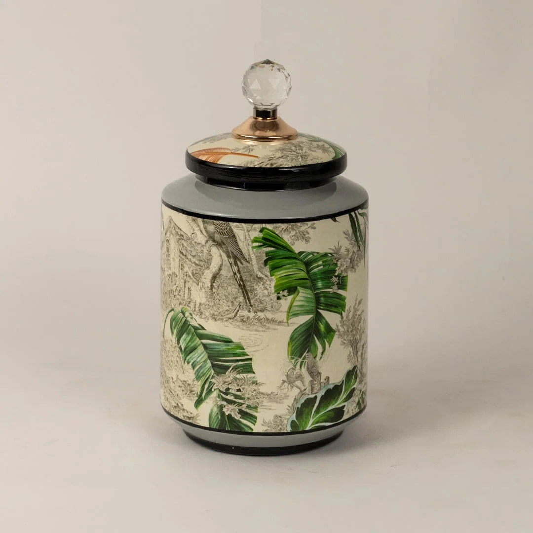 Side angle of tropical bird jar showing smooth cylindrical shape glossy finish and tropical foliage design.