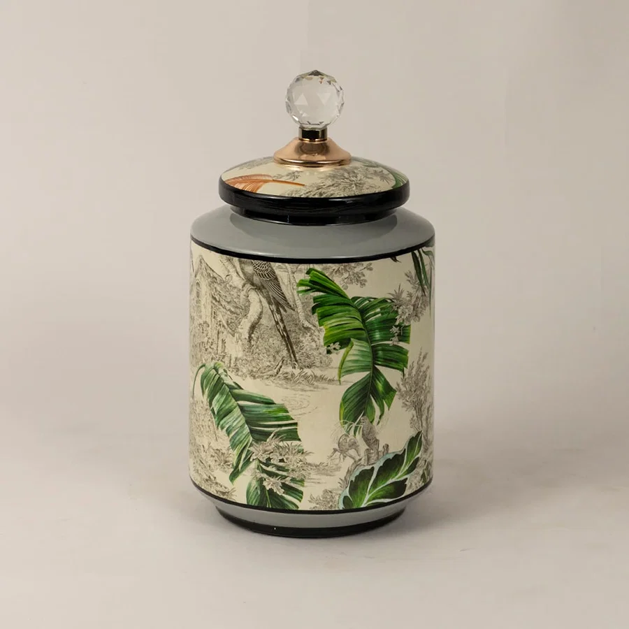 Side angle of tropical bird jar showing smooth cylindrical shape glossy finish and tropical foliage design.