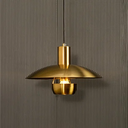Golden metal pendant light shining warmly on dark background accentuating its smooth curves and contemporary luxe appeal.