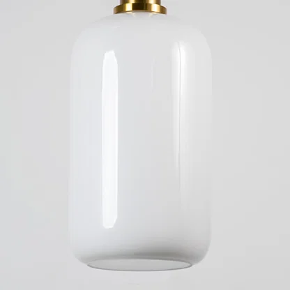 White glass pendant light with brass metal fixture showcasing smooth glossy finish and refined contemporary lighting style.
