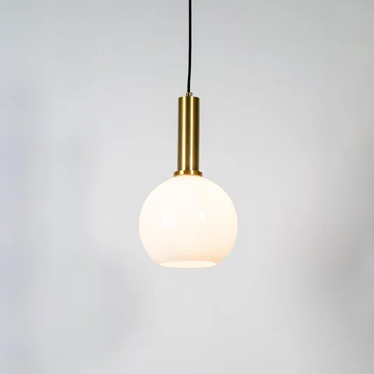 White glass globe pendant light with brass metal holder and minimalist design for contemporary ceiling lighting decor.