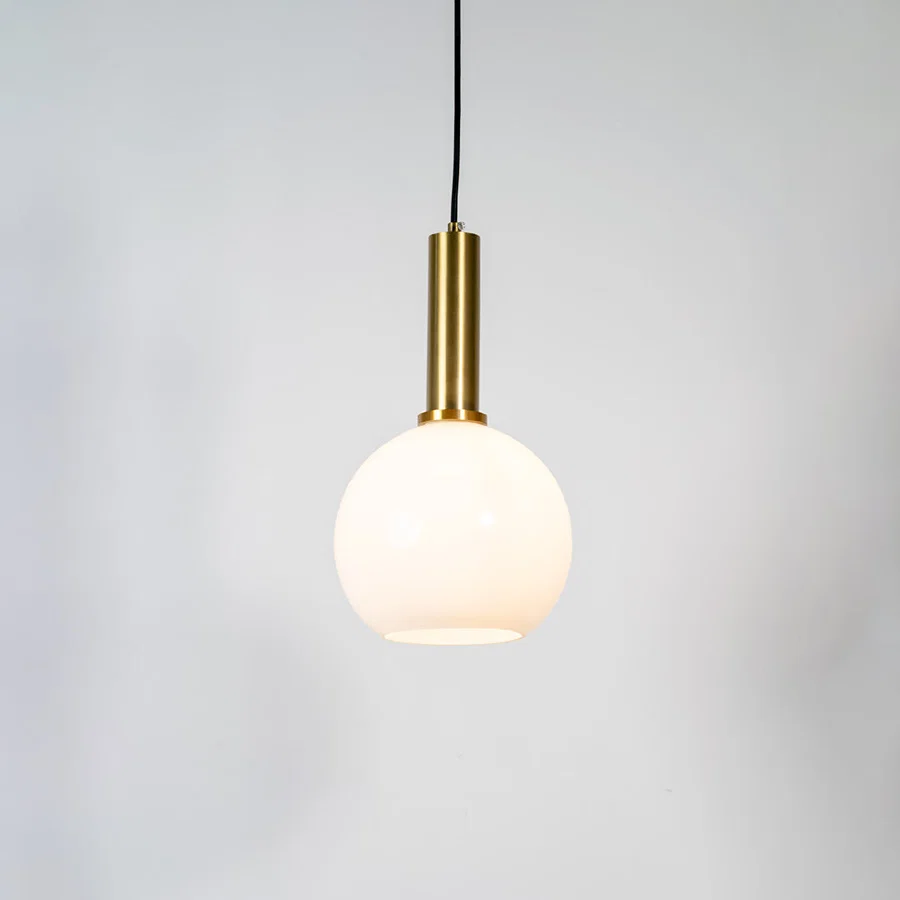 White glass globe pendant light with brass metal holder and minimalist design for contemporary ceiling lighting decor.