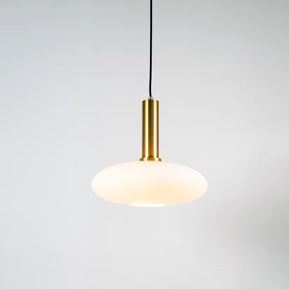 White glass pendant light with brass metal holder and modern disc design for elegant contemporary ceiling lighting decor.