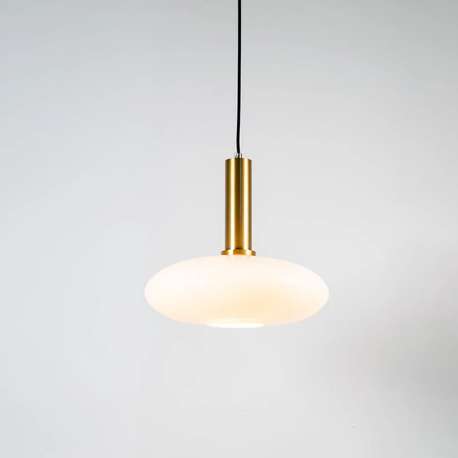White glass pendant light with brass metal holder and modern disc design for elegant contemporary ceiling lighting decor.