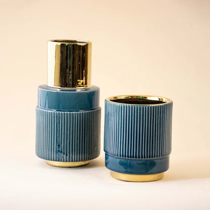 Set of blue ceramic decorative vases with fluted texture and gold accents for coordinated modern home decor displays.