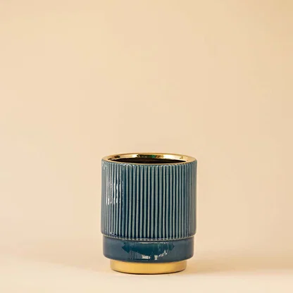 Blue ceramic decorative vase with fluted texture and gold rim for sophisticated shelf styling and home decor.