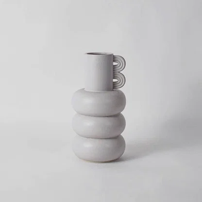 White ceramic decorative vase with stacked rounded silhouette for shelf styling and minimalist home decor displays.