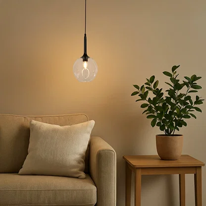 White glass pendant light with brass details creating warm cozy lighting beside sofa in modern living spaces.