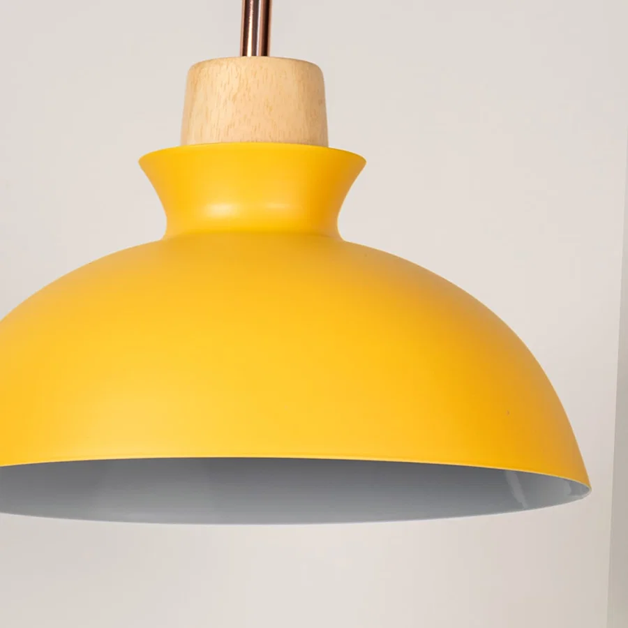 Yellow metal pendant light with natural wood detailing showcasing smooth dome shape and modern Scandinavian design appeal.