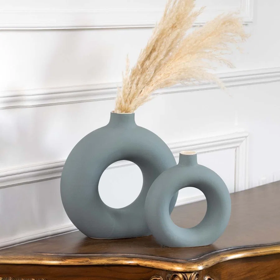 Set of two green ceramic donut vases with matte finish modern round hollow design styled for pampas grass decoration.