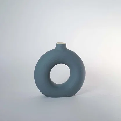 Blue ceramic decorative vase with hollow ring design for shelf styling and contemporary home decor displays.