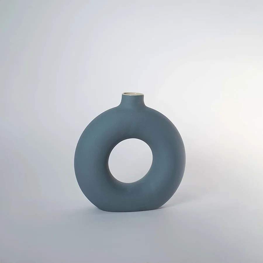 Blue ceramic decorative vase with hollow ring design for shelf styling and contemporary home decor displays.