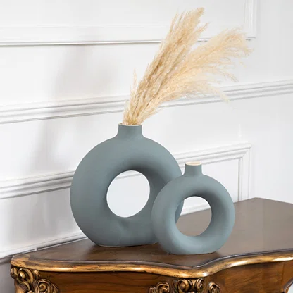 Blue ceramic ring vase set with dried pampas grass on a console table for contemporary home decor styling.