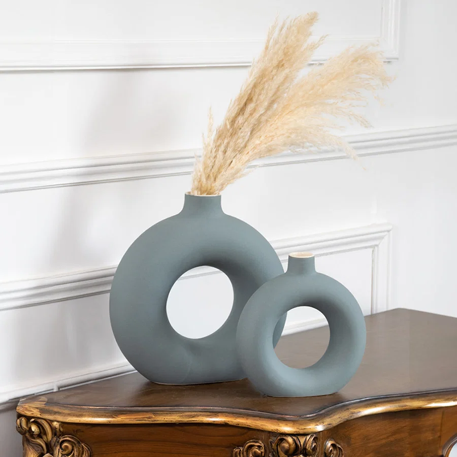 Blue ceramic ring vase set with dried pampas grass on a console table for contemporary home decor styling.