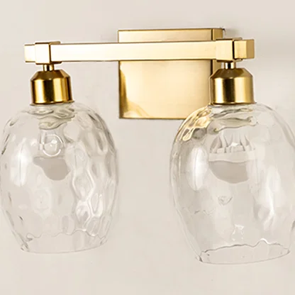 Closeup of clear textured glass and gold metal wall light for elegant hallway and premium decor spaces.