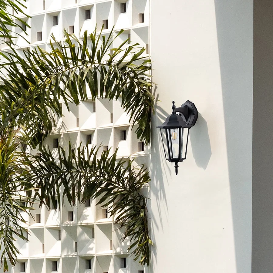 Black metal outdoor wall light lifestyle image on modern exterior wall for elegant patio lighting decor.
