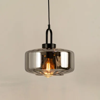 Modern smoked glass pendant light with black metal accents for luxury kitchen and dining room decor styling.