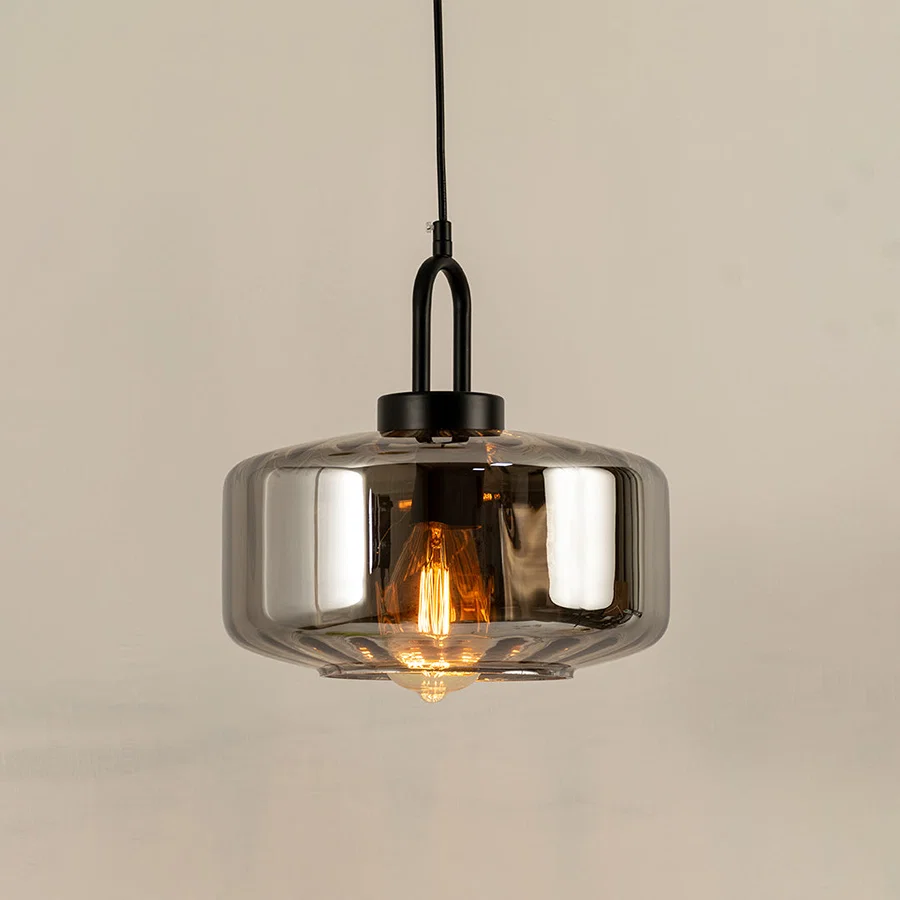 Modern smoked glass pendant light with black metal accents for luxury kitchen and dining room decor styling.