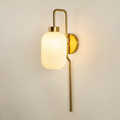 Modern gold metal wall light with ribbed white glass shade for elegant hallway and luxury decor spaces.