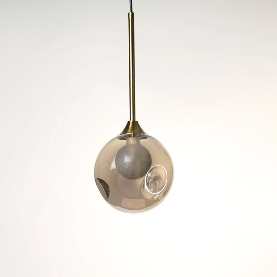 Smoky grey glass globe pendant light with polished brass accents crafted for elegant interiors.