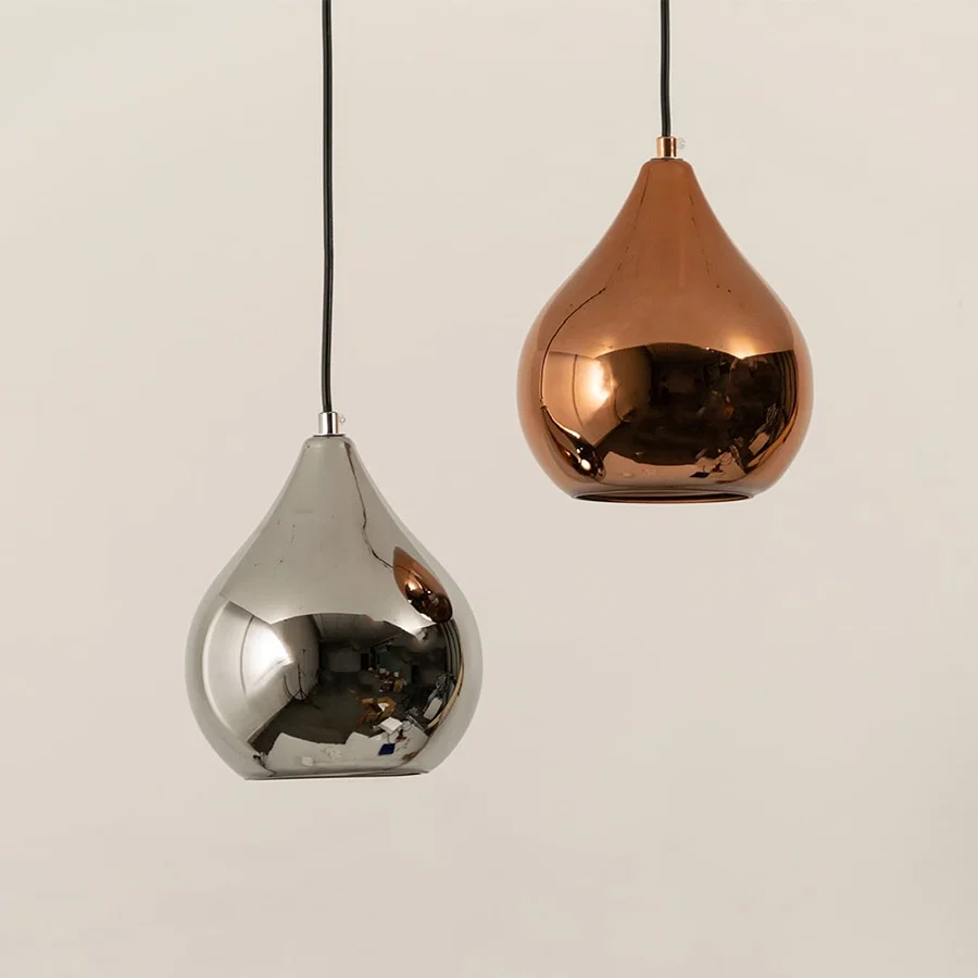 Silver and copper metal pendant lights illuminated to display contemporary decorative ceiling lighting with premium appeal.