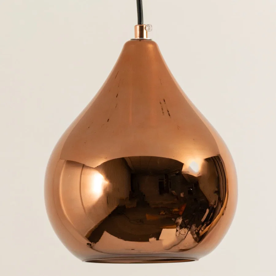 Copper metal pendant light illuminated to showcase reflective modern ceiling lighting with luxury decorative appeal.