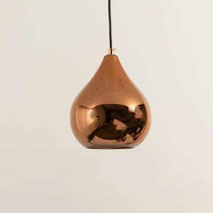 Copper metal pendant light illuminated to showcase reflective modern ceiling lighting with luxury decorative appeal.