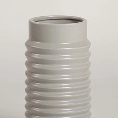 Closeup of light grey ribbed ceramic vase highlighting its smooth glossy finish and textured detailing ideal for modern home styling.