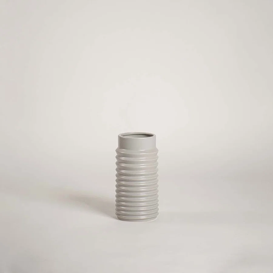 Modern light grey ceramic vase with ribbed design displayed on a white background ideal for minimalist decor and tabletop styling.