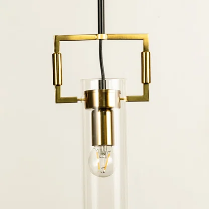 Gold metal wall light with clear glass bulb illuminated to showcase elegant modern decorative wall lighting design.