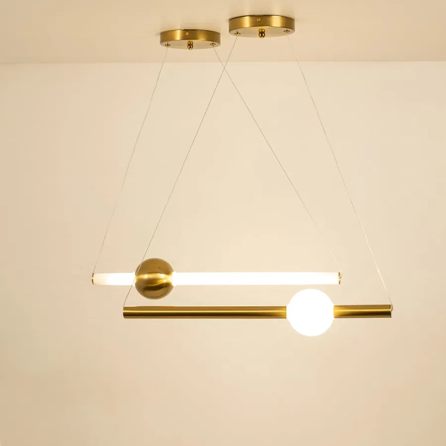Gold metal linear pendant light illuminated with frosted globe shade showcasing modern ceiling lighting elegance.