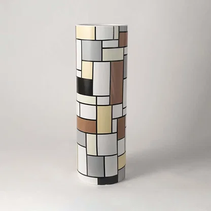 Tall ceramic cylinder vase featuring a multi-colored abstract geometric block grid pattern on clean white background.