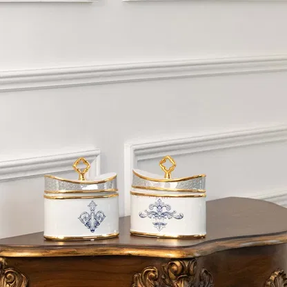 White and gold rectangular ceramic jars with blue artwork in a front view ideal for elegant décor styling and modern tabletop display.
