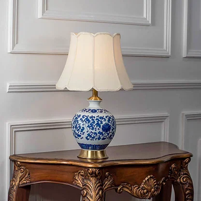 Blue floral ceramic table lamp with fabric shade displayed on a wooden console table offering timeless decor lighting.