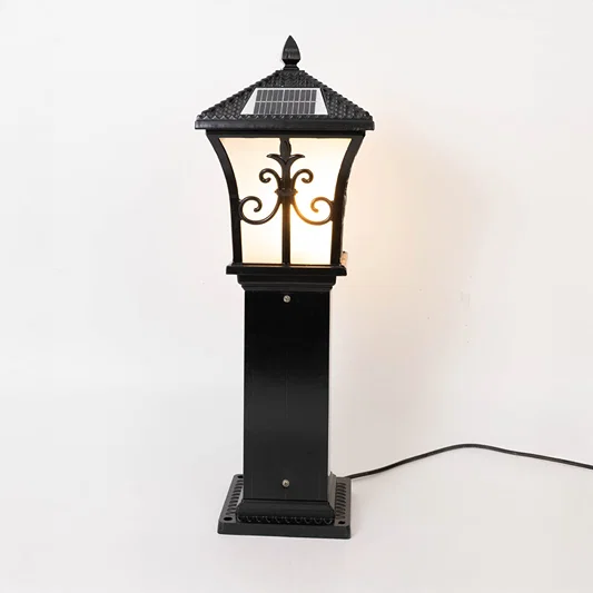 Vintage black outdoor gate light with warm glowing glass panels for elegant exterior decor use.