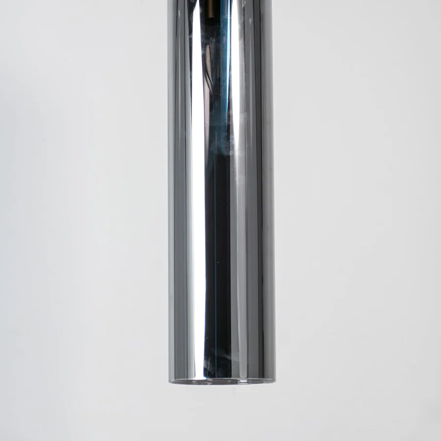 Chrome metal pendant light with reflective polished finish and sleek cylindrical form for modern luxury interior decor.