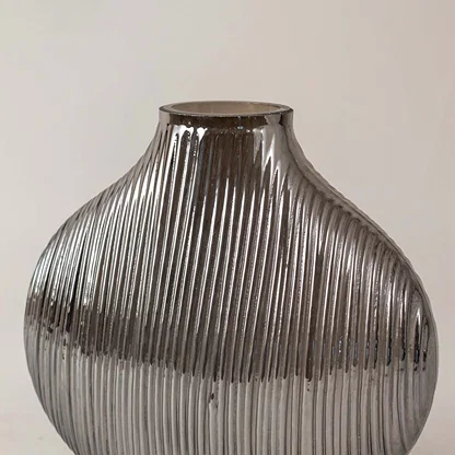 Textured smoked grey glass vase with vertical ribbing design adds contemporary style to any living room shelf decor.